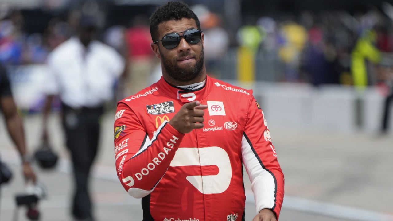 Bubba Wallace walks to his car during qualifications for a NASCAR Cup Series auto race at Michigan International Speedway in Brooklyn, Mich., Saturday, Aug. 5, 2023. (AP Photo/Paul Sancya)