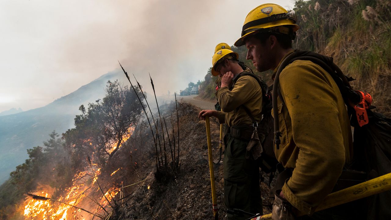 Firefighters monitor a controlled burn along Nacimiento-Fergusson Road to help contain the Dolan Fire near Big Sur, Calif., Friday, Sept. 11, 2020. (AP Photo/Nic Coury)