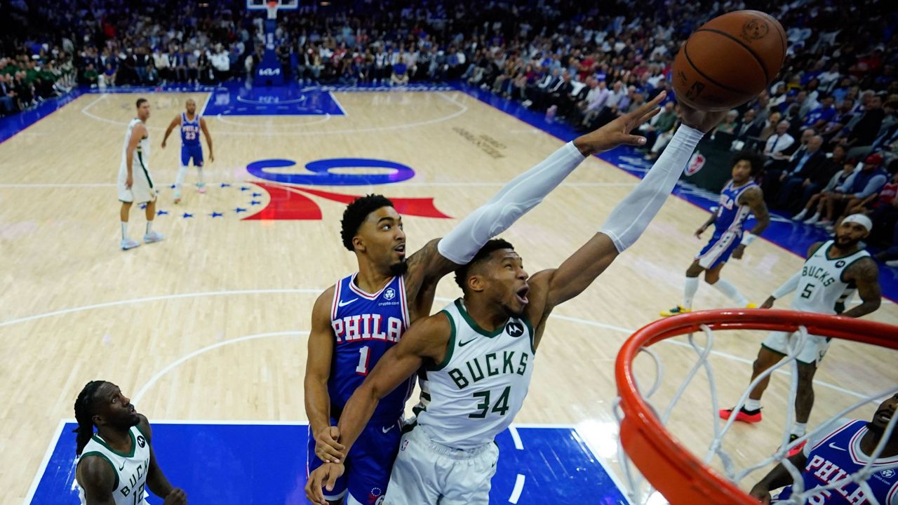 Philadelphia 76ers' KJ Martin (1) and Milwaukee Bucks' Giannis Antetokounmpo (34) reach for a rebound during the first half of an NBA basketball game, Wednesday, Oct. 23, 2024, in Philadelphia. (AP Photo/Matt Slocum)