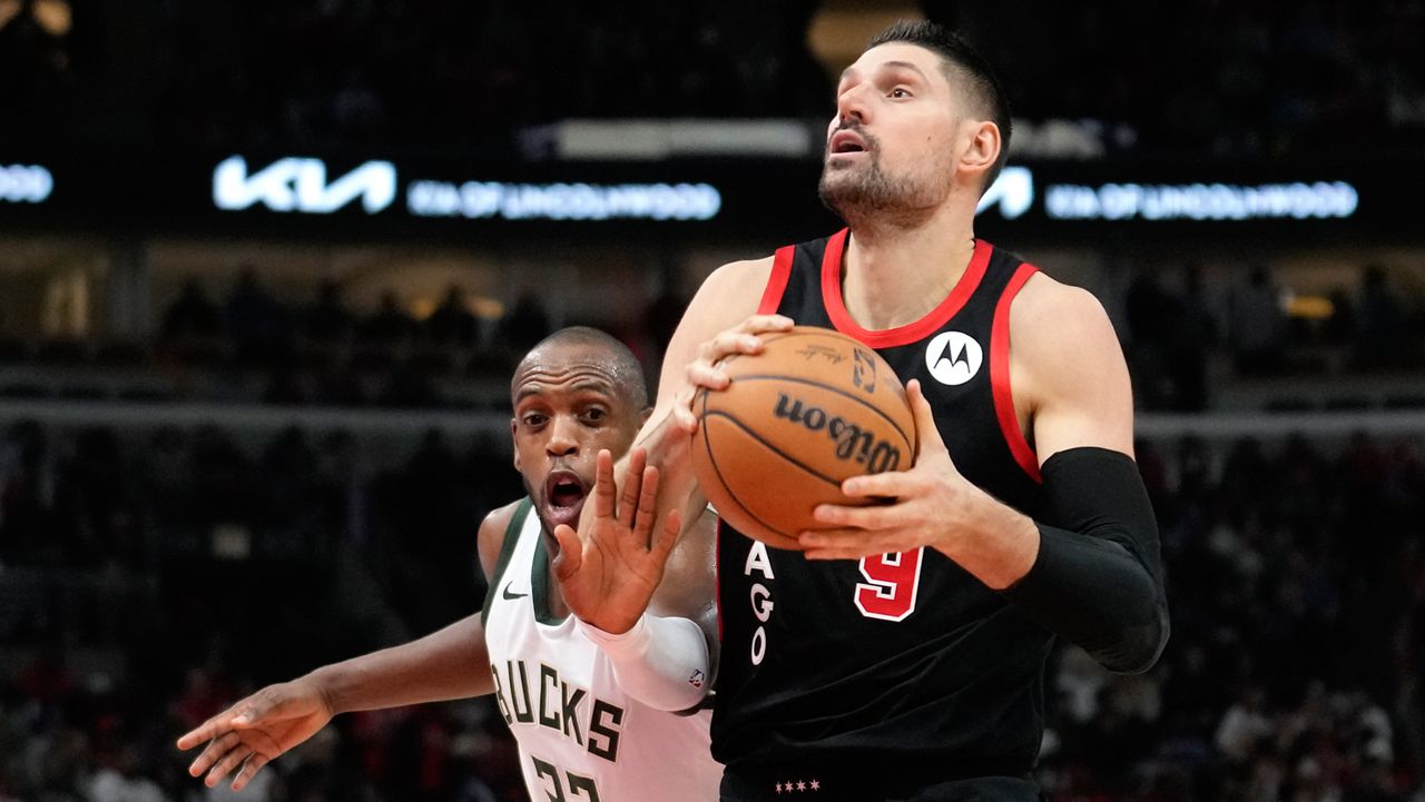 Chicago Bulls' Nikola Vucevic eyes the basket as Milwaukee Bucks' Khris Middleton defends