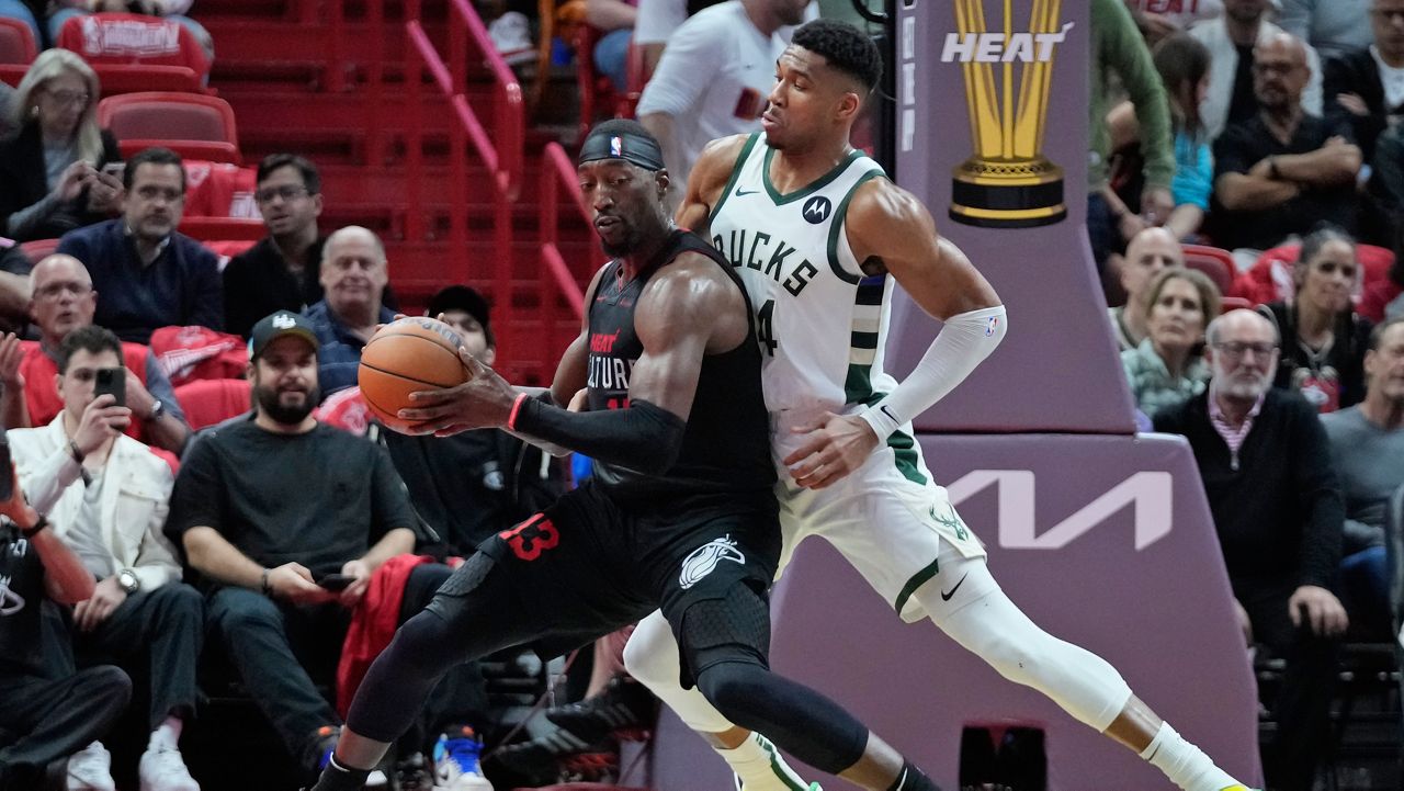 Miami Heat center Bam Adebayo (13) drives to the basket against Milwaukee Bucks forward Giannis Antetokounmpo 