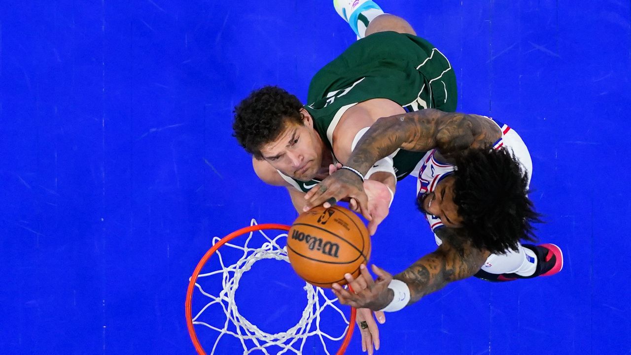 Philadelphia 76ers' Kelly Oubre Jr., right, goes up for a shot against Milwaukee Bucks' Brook Lopez