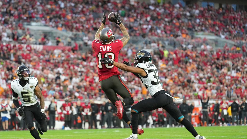 Tampa Bay Buccaneers wide receiver Mike Evans (13) catches his second touchdown of the first half as Jacksonville Jaguars cornerback Tyson Campbell (32) defends during an NFL football game, Sunday, Dec. 24, 2023, in Tampa, Fla. (AP Photo/Peter Joneleit)