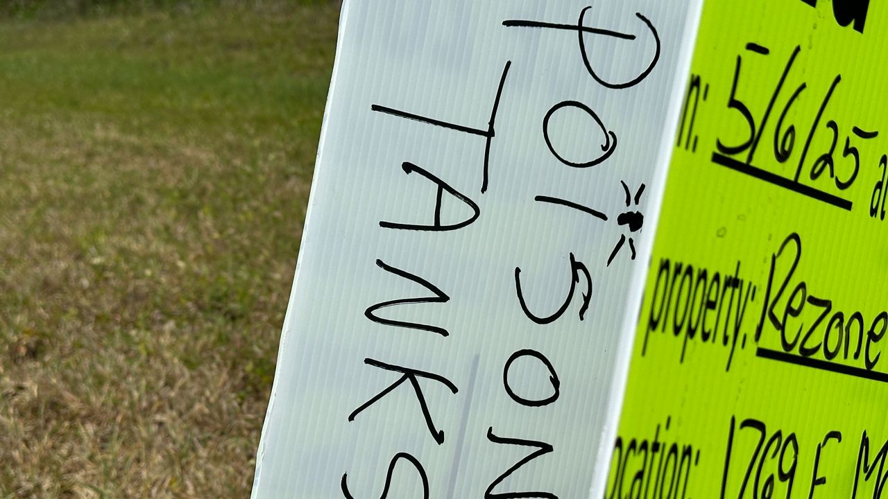 A sign advertising a meeting about rezoning that was ripped in half with 