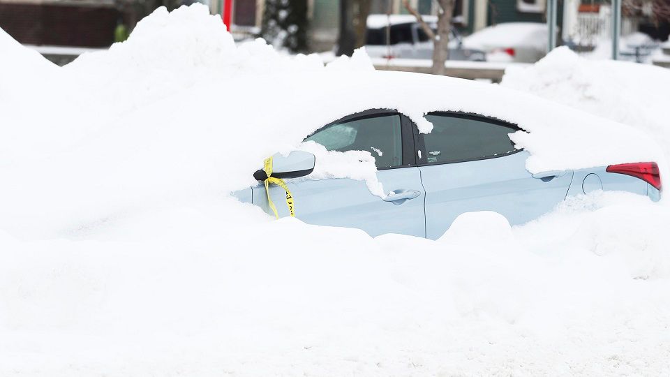 An abandoned car is covered in snow on Main Street in Buffalo, N.Y., on Tuesday, December 27, 2022, days after a blizzard hit four Western New York counties. (Joseph Cooke/The Buffalo News via AP)