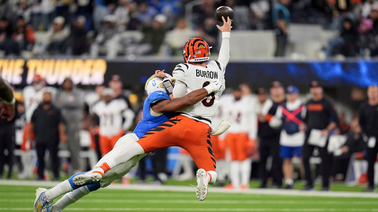 Cincinnati Bengals quarterback Joe Burrow (9) throws as he is tackled by Los Angeles Chargers linebacker Daiyan Henley (0) during the second half of an NFL football game Sunday, Nov. 17, 2024, in Inglewood, Calif. 