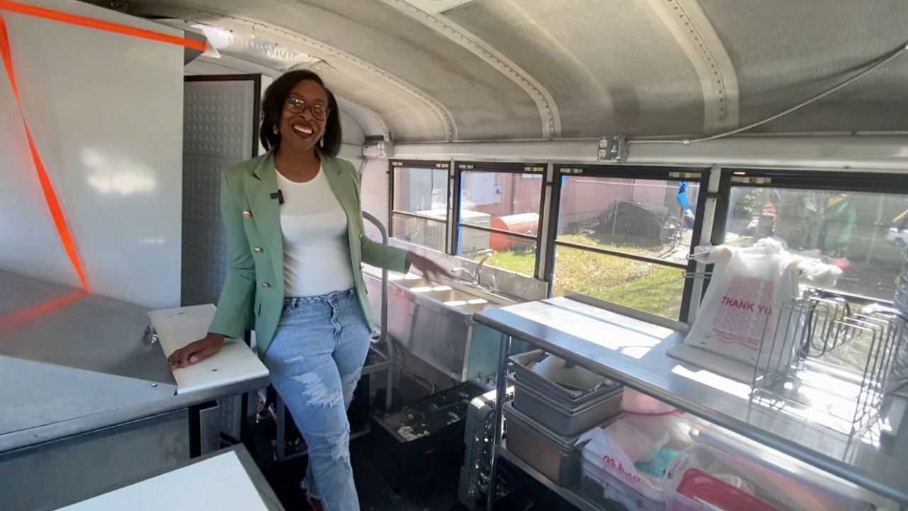 Chef Teshia Bailey stands inside her bus that she's transforming into a food truck 