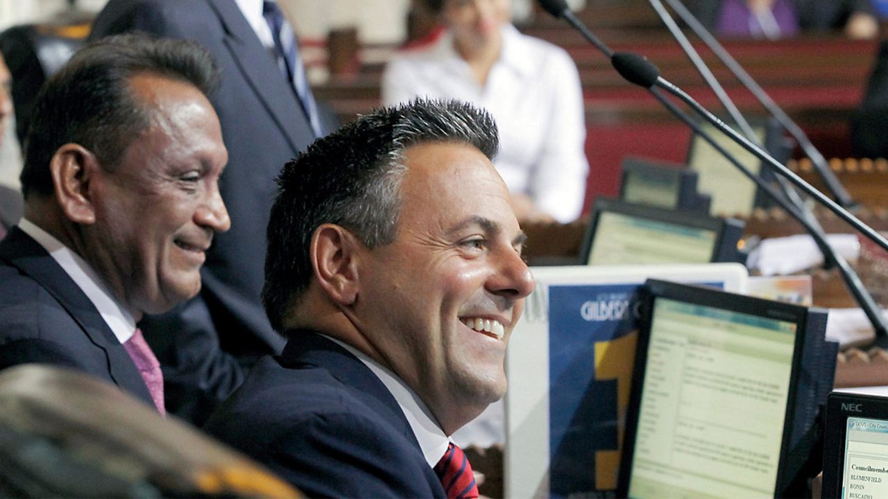 Councilman Joe Buscaino smiles after a city council vote in Los Angeles, Sept. 1, 2015. (AP Photo/Nick Ut)