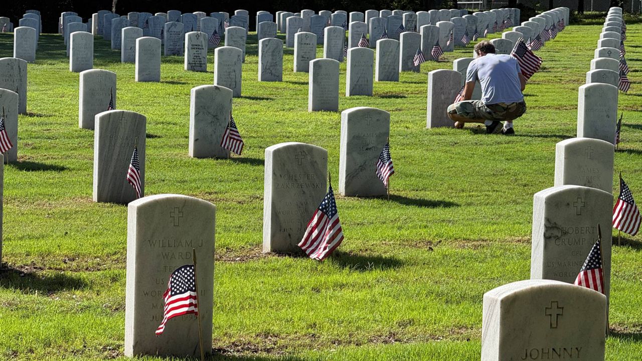 Volunteers place flags at Florida National Cemetery ahead of Memorial Day