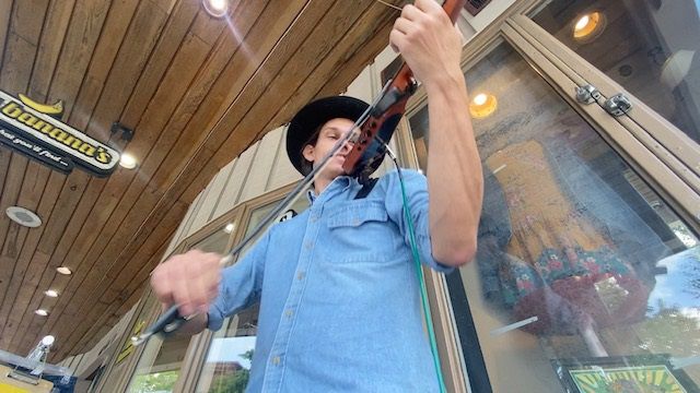 Timothy Kelley is playing an electric fiddle on king street 