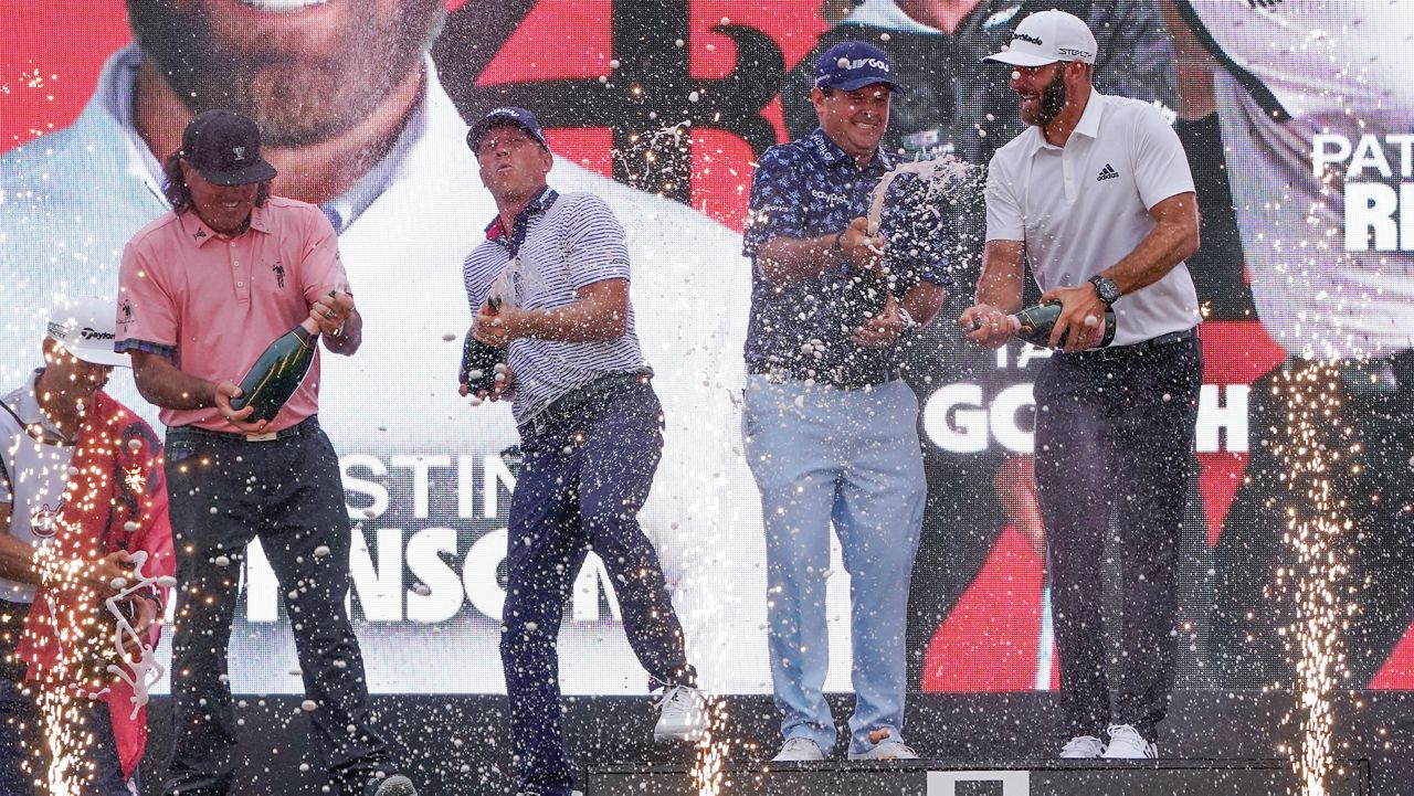 The "4 Aces" team celebrates with champagne after winning the team competition during a ceremony after the final round of the Bedminster Invitational LIV Golf tournament in Bedminster, N.J., Sunday, July 31, 2022. From left to right, Pat Perez, Talor Gooch, Patrick Reed and Dustin Johnson. (AP Photo/Seth Wenig)
