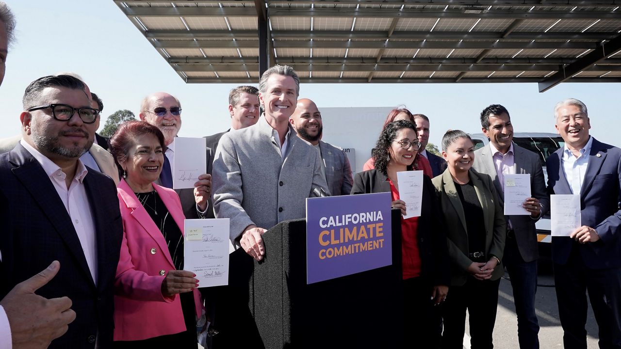 Gov. Gavin Newsom, center, poses with lawmakers after signing a package of legislation that accelerates the climate goals of the nation's most populous state at Mare Island in Vallejo, Calif., Friday, Sept. 16, 2022. (AP Photo/Rich Pedroncelli)