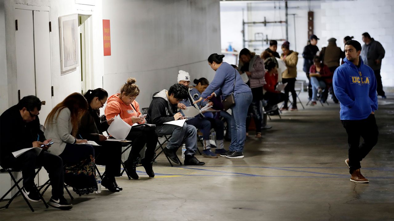 In this March 13, 2020, file photo, unionized hospitality workers wait in line in a basement garage to apply for unemployment benefits at the Hospitality Training Academy in Los Angeles. California's unemployment rate nearly tripled in April because of the economic fallout from coronavirus pandemic. (AP Photo/Marcio Jose Sanchez, File)