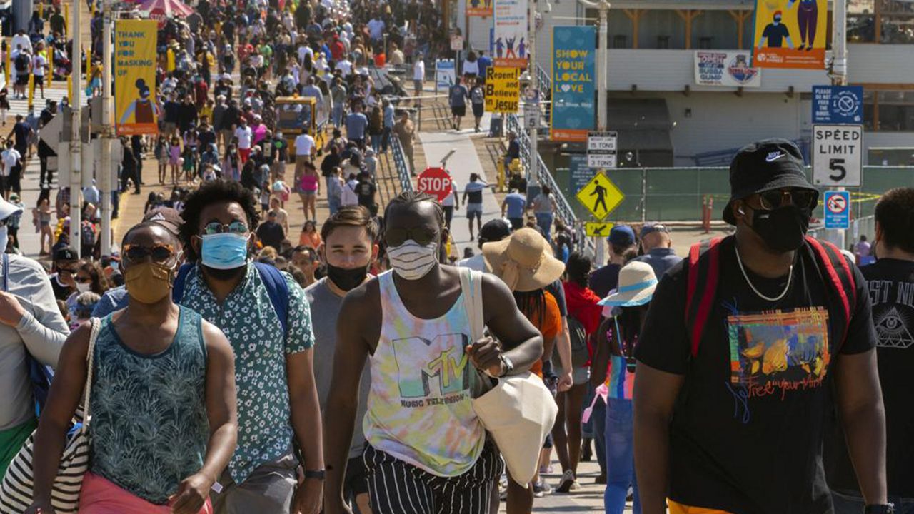 In this Saturday, May 29, 2021, file photo, people crowd the Santa Monica Pier in Santa Monica, Calif. California, the first state in America to put in place a coronavirus lockdown, is now turning a page on the pandemic. Most of California's coronavirus restrictions will disappear Tuesday, June 15, 2021. (AP Photo/Damian Dovarganes, File)