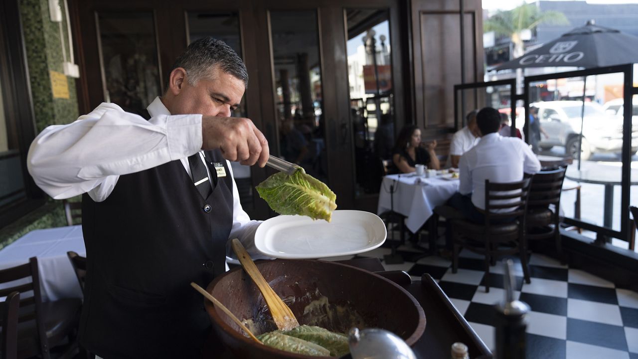 Salad Master Efrain Montoya prepares a Caesar salad at Ceasar's restaurant Thursday, June 27, 2024, in Tijuana, Mexico. (AP Photo/Gregory Bull)