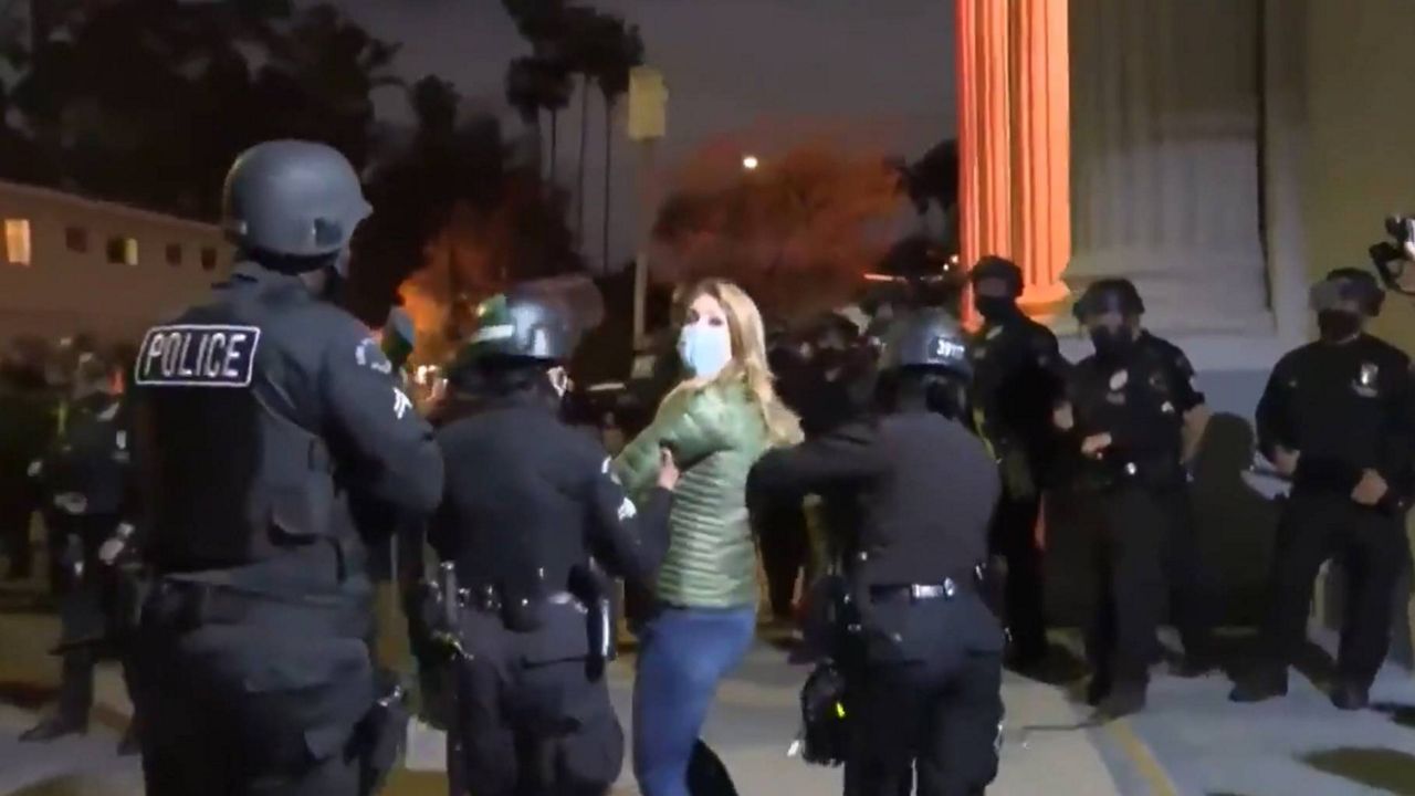 Spectrum News 1's Kate Cagle being detained by LAPD while covering the clearing of Echo Park.