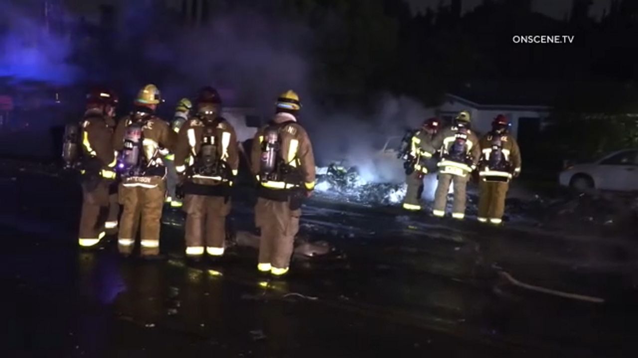 First responders standing around a crash site.