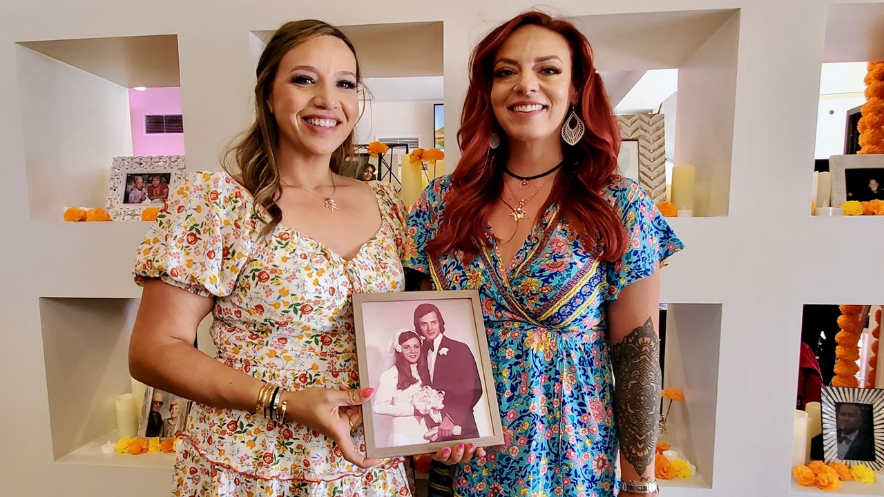 Mariam and Angela El Haj hold a photo of their parents at Calaca Mamas Cantina in Anaheim (Spectrum News/Joseph Pimentel)