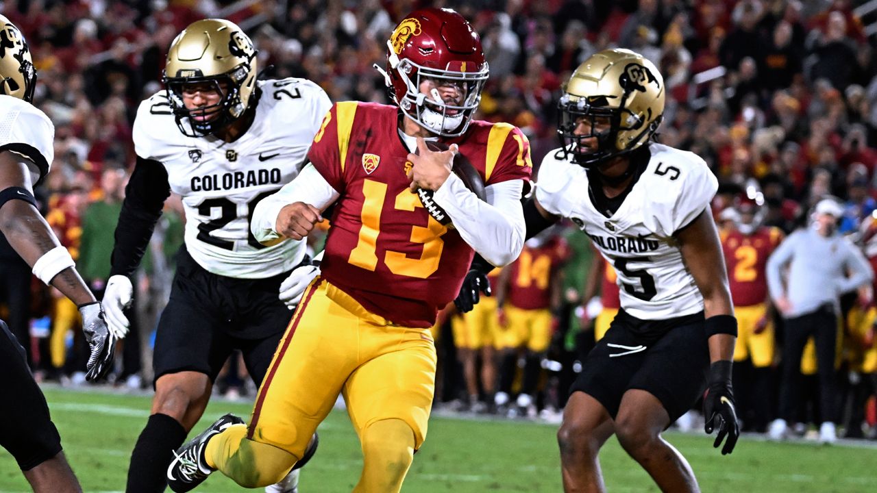 Southern California quarterback Caleb Williams scores a touchdown, getting past Colorado's Robert Barnes, left, and Tyrin Taylor during the first half of an NCAA college football game Friday, Nov. 11, 2022, in Los Angeles. (AP Photo/John McCoy)