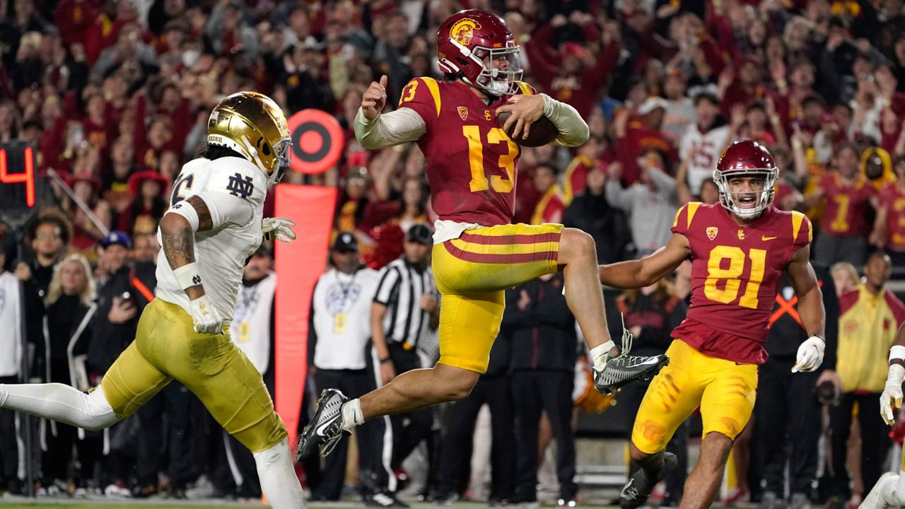 Southern California quarterback Caleb Williams jumps in for a touchdown as Notre Dame safety Xavier Watts, left, defends and Southern California wide receiver Kyle Ford watches during the second half of an NCAA college football game Saturday, Nov. 26, 2022, in Los Angeles. (AP Photo/Mark J. Terrill)