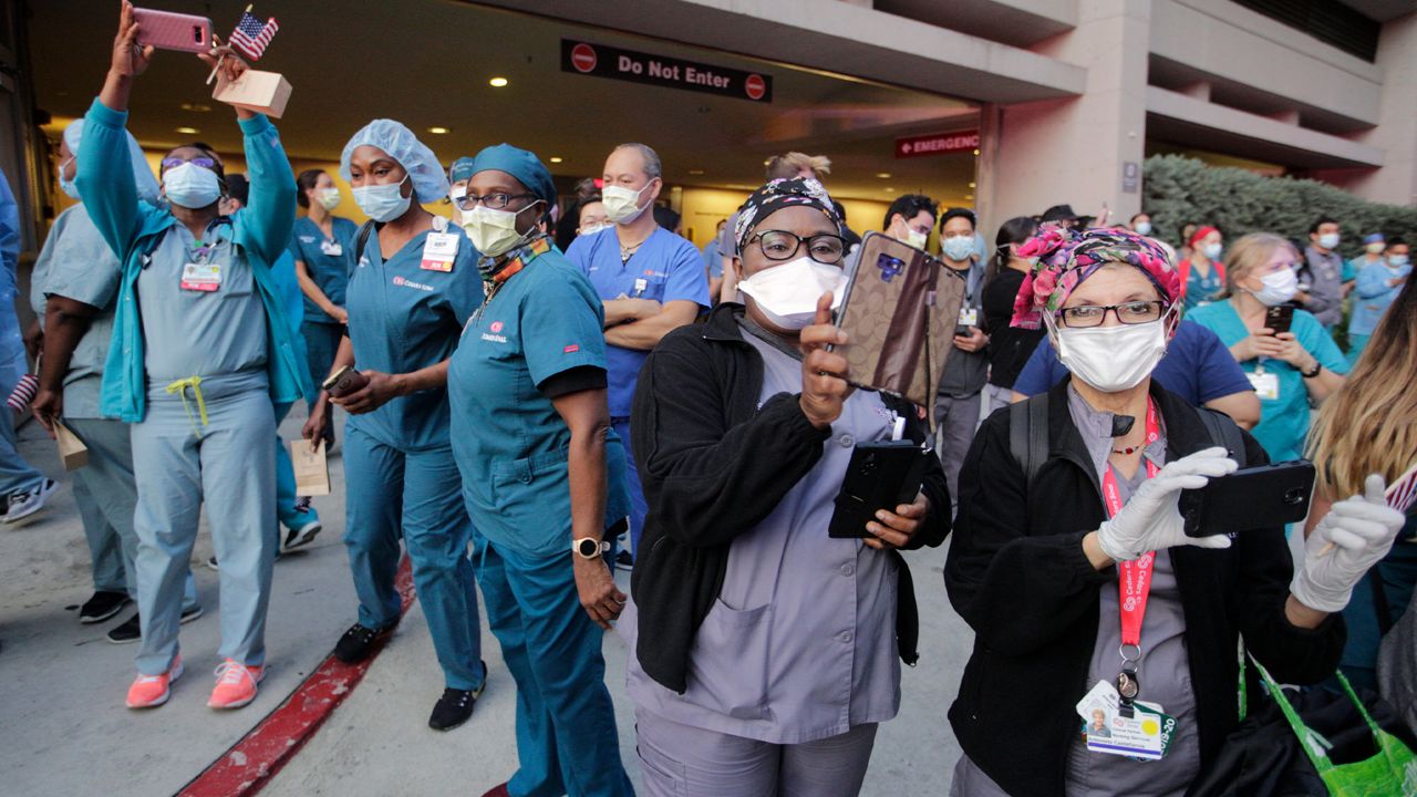 Medical personnel take pictures during a parade at Cedars-Sinai Medical Center, Wednesday, May 6, 2020, in West Hollywood, Calif., in a show of support for nurses and health care workers on National Nurses Day. (AP Photo/Damian Dovarganes)