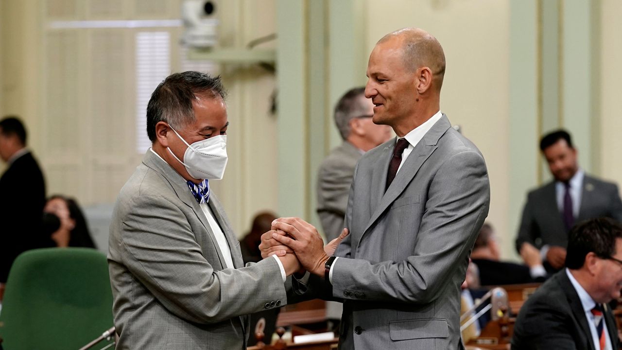 Assemblyman Phil Ting, D-San Francisco, chair of the Assembly budget committee, left, is congratulated by fellow Democratic Assemblyman Kevin McCarty, of Sacramento, after the Assembly approved the state budget bill, at the Capitol in Sacramento, Calif., on Monday. (AP Photo/Rich Pedroncelli
