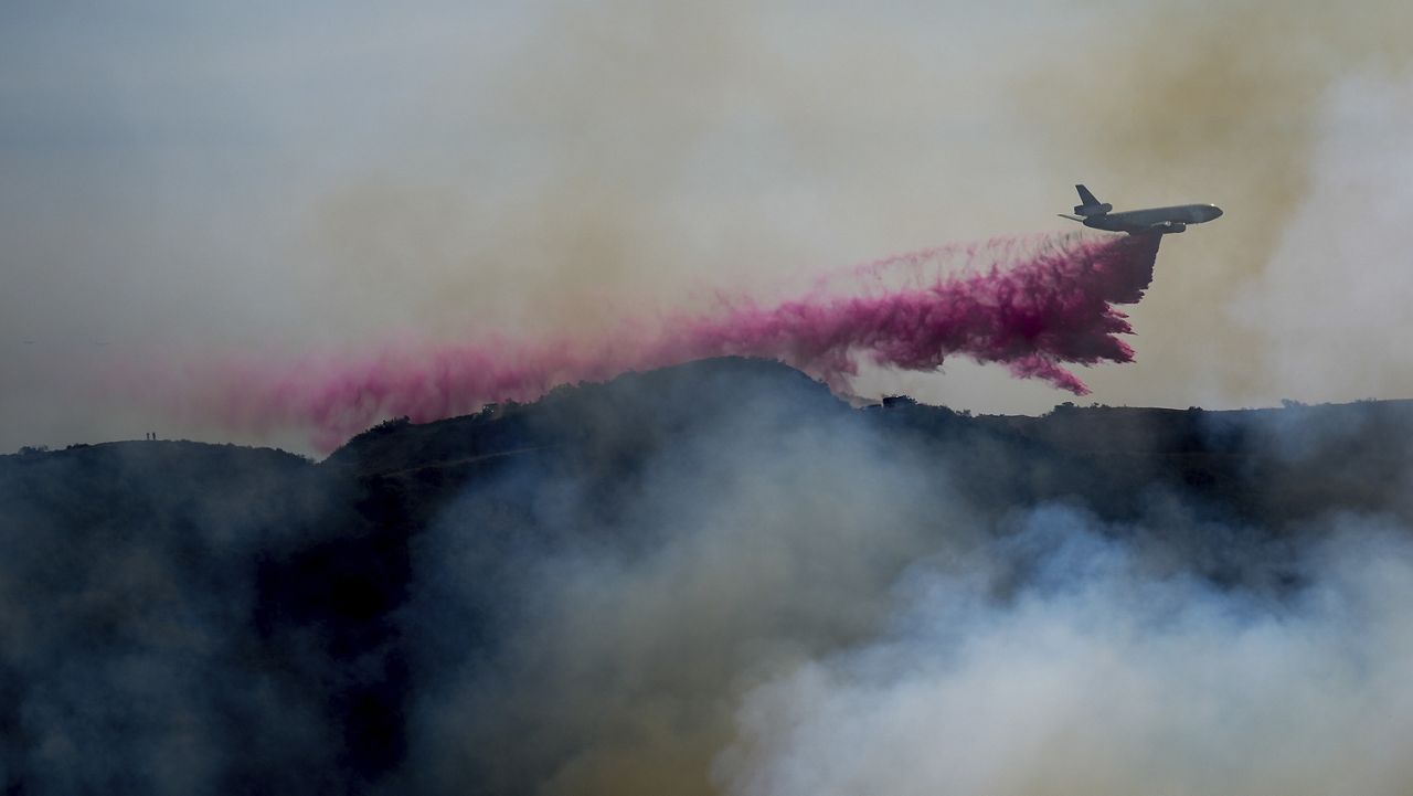 Fire retardant is dropped by an air tanker on the Palisades Fire in the outskirts of the Pacific Palisades neighborhood of Los Angeles, Jan. 10, 2025. (AP Photo/Eric Thayer)