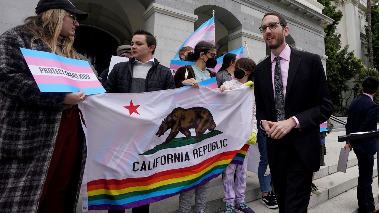 State Sen. Scott Wiener, D-San Francisco, right, prepares to announce his proposed measure to provide legal refuge to displaced transgender youth and their families during a news conference in Sacramento, Calif., Thursday, March 17, 2022. (AP Photo/Rich Pedroncelli)