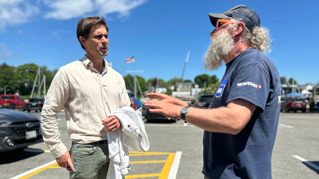 Tom Hedstrom, chair of the Select Board, speaks with schooner captain Aaron Lincoln during a visit to the harbor, Tuesday, June 4, in Camden. Hedstrom said residents were united in their anger over one homeowner's poisoning of a neighbor's trees to gain a view, especially due to the proximity of the water. (AP Photo/Robert F. Bukaty)