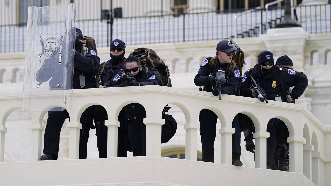Police keep a watch on demonstrators who tried to break through a police barrier at the Capitol on Jan. 6. (AP Photo/Julio Cortez, File)