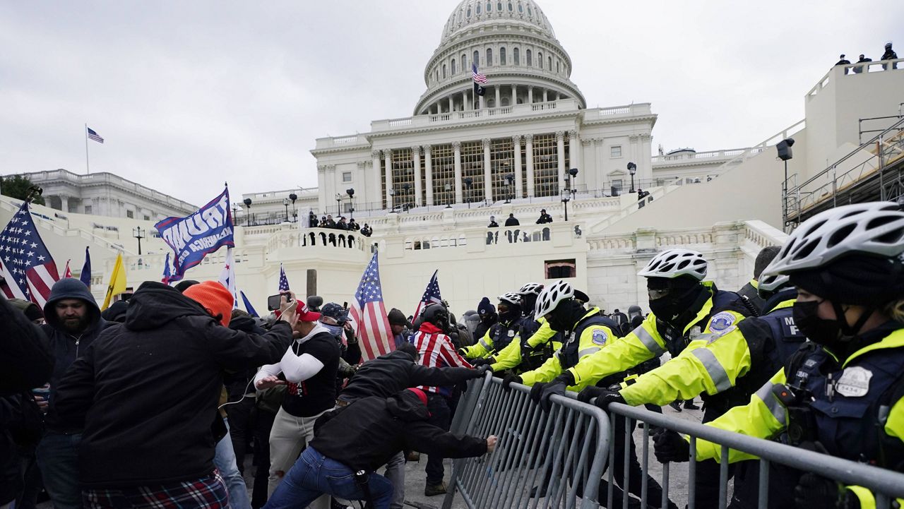 In this file photo from January 6, law enforcement officers try to hold off a pro-Trump mob in front of the U.S. Capitol. (AP file)