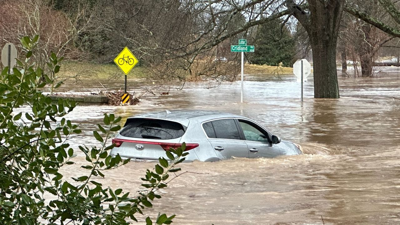 A car is engulfed by floodwaters along Cridland and Latham Road in Greensboro. (Spectrum News 1/Sydney McCoy)