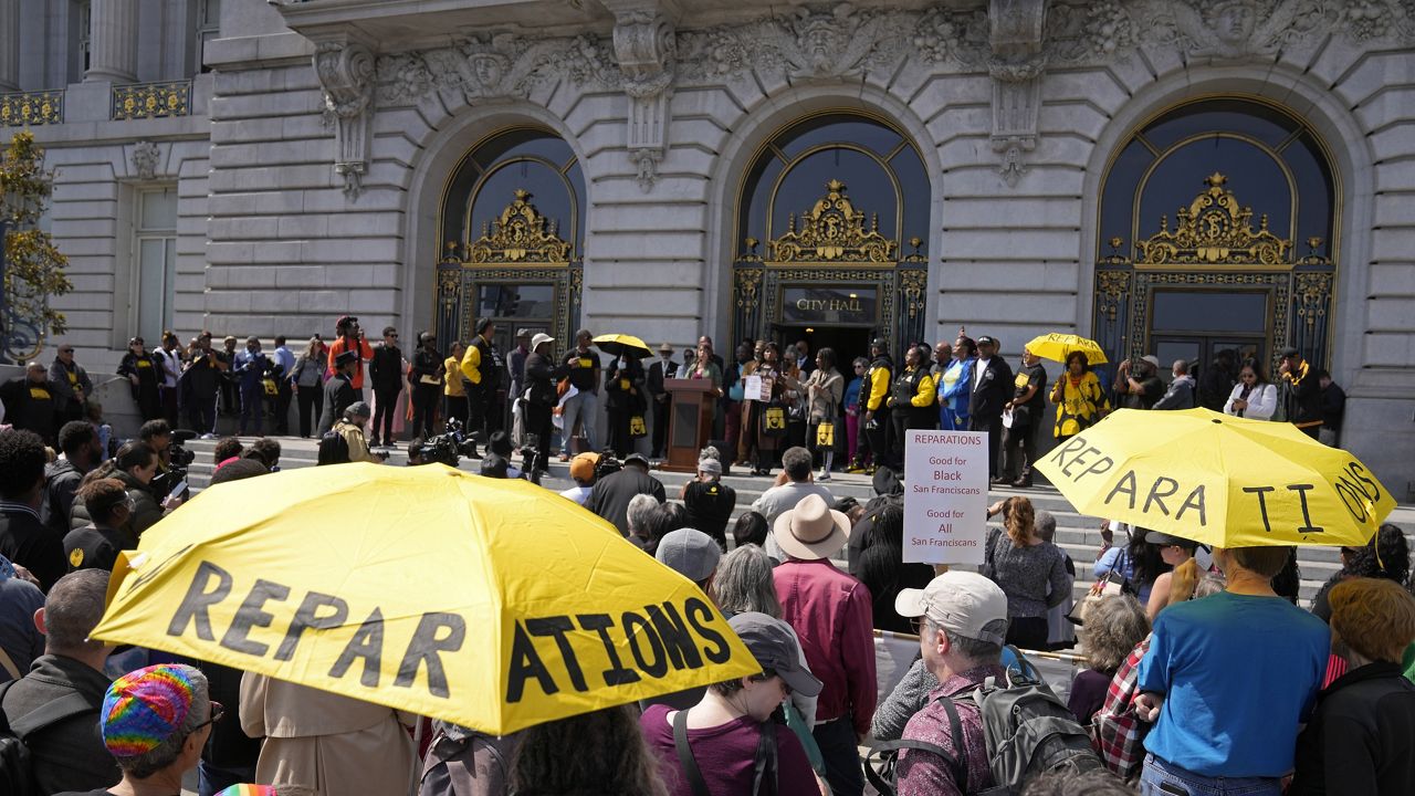 People listen during a rally in support of reparations for African Americans outside City Hall in San Francisco, Tuesday, Sept. 19, 2023. (AP Photo/Eric Risberg, File)