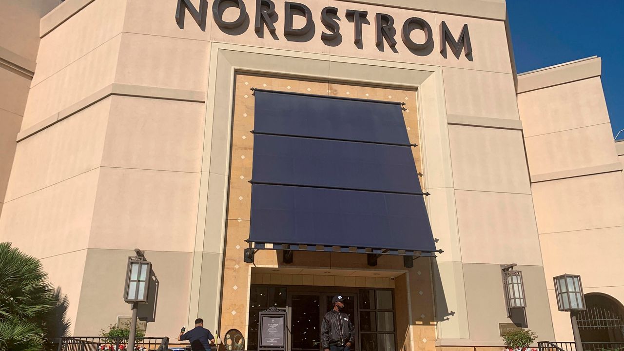 A security guard stands outside the Nordstrom store at The Grove retail and entertainment complex in Los Angeles, on Nov. 23, 2021. (AP Photo/Eugene Garcia, File)
