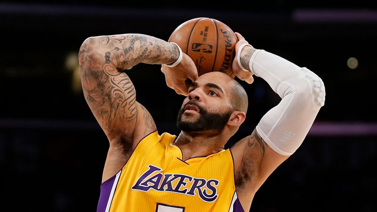 In this March 12, 2015, file photo, Los Angeles Lakers' Carlos Boozer shoots against the New York Knicks in Los Angeles. Boozer's twin sons announced Friday their commitment to join Duke, where their father played in 1999-2002. (AP File Photo/Danny Moloshok)