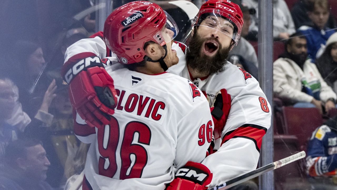 Carolina Hurricanes' Jack Roslovic (96) celebrates his goal with Brent Burns (8) during the first period of an NHL hockey game against the Vancouver Canucks in Vancouver, British Columbia, Monday, Oct. 28, 2024. (Ethan Cairns/The Canadian Press via AP)