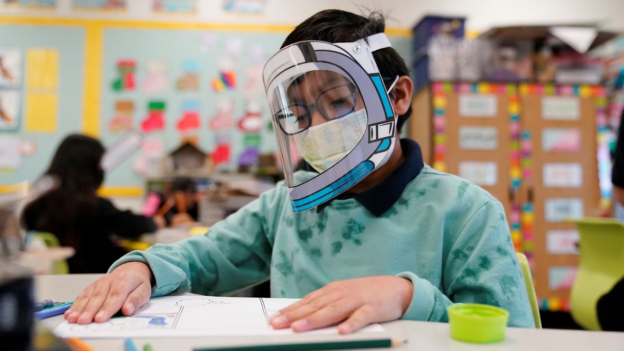 A student wears a mask and face shield in a 4th grade class amid the COVID-19 pandemic at Washington Elementary School on Jan. 12, 2022, in Lynwood, Calif.