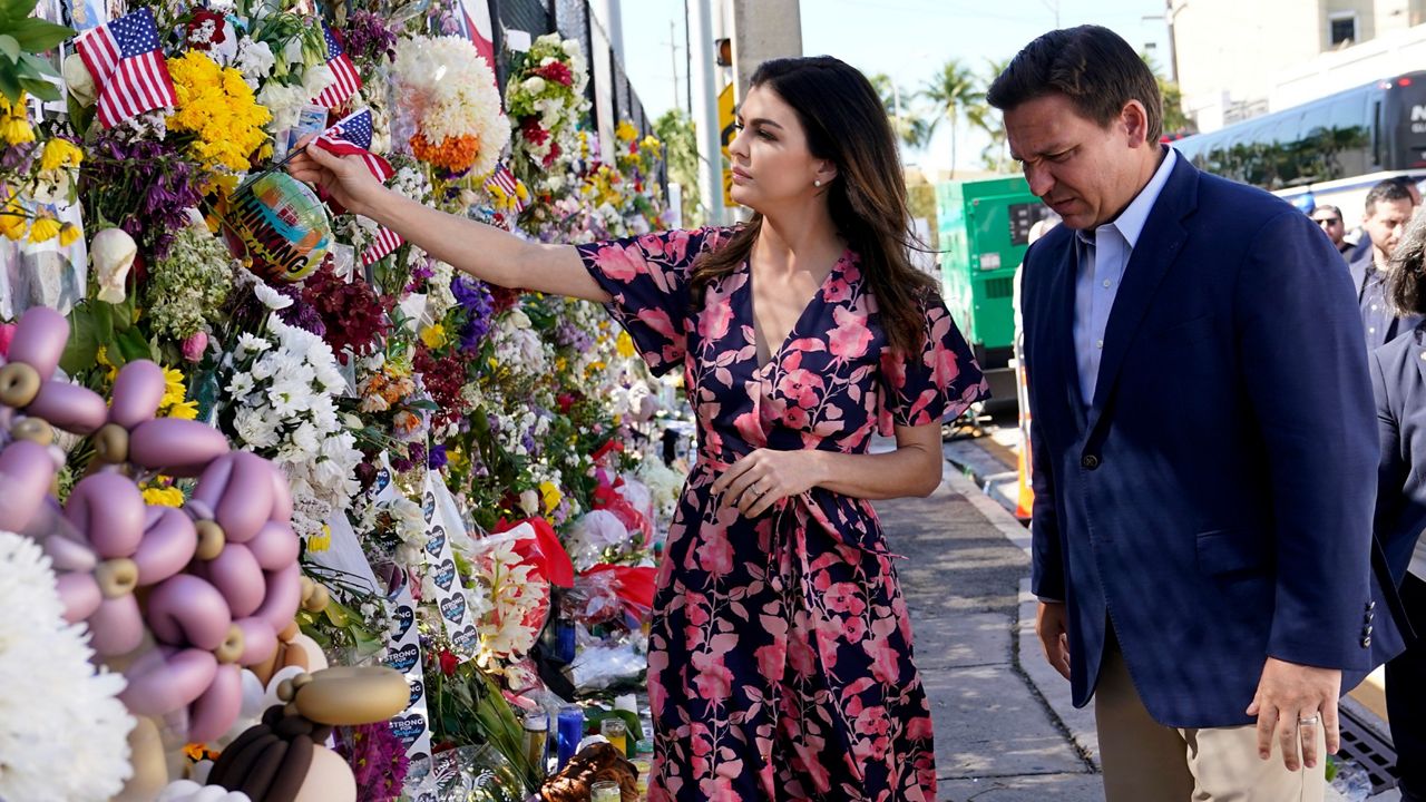 Florida Gov. Ron DeSantis, left, and his wife Casey leave flags at a makeshift memorial near the Champlain Towers South condo building (AP/Lynne Sladky)