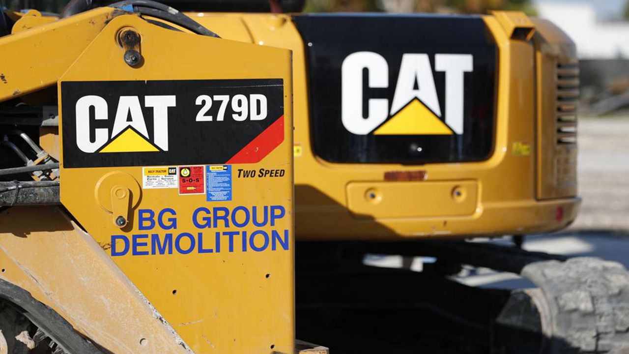 FILE - This May 8, 2019 photo shows a Caterpillar 279D Compact Track Loader, left, and 308E2 CR Mini Hydraulic Excavator, right, rear, at a demolition site in Fort Lauderdale, Fla. Construction equipment manufacturer Caterpillar says it's packing up its headquarters from its longtime home state of Illinois and heading to Texas. Caterpillar Inc. said Tuesday, June 14, 2022, that it's transferring its global base to Irving, Texas, from the Chicago suburb of Deerfield, Illinois. (AP Photo/Wilfredo Lee, File)