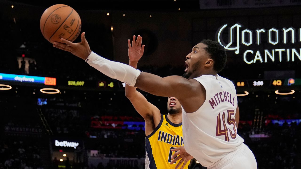 Cleveland Cavaliers guard Donovan Mitchell (45) goes to the basket past Indiana Pacers guard Tyrese Haliburton, left, in the second half during Game 1 in the Eastern Conference semifinals of the NBA basketball playoffs Sunday, May 4, 2025, in Cleveland. (AP Photo/Sue Ogrocki)