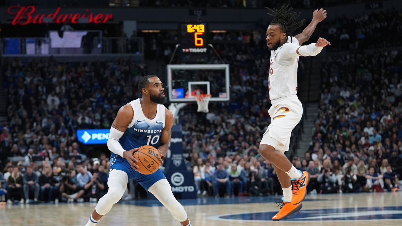 Minnesota Timberwolves guard Mike Conley (10) looks to shoot as Cleveland Cavaliers guard Darius Garland defends during the first half of an NBA basketball game Friday, March 22, 2024, in Minneapolis.
