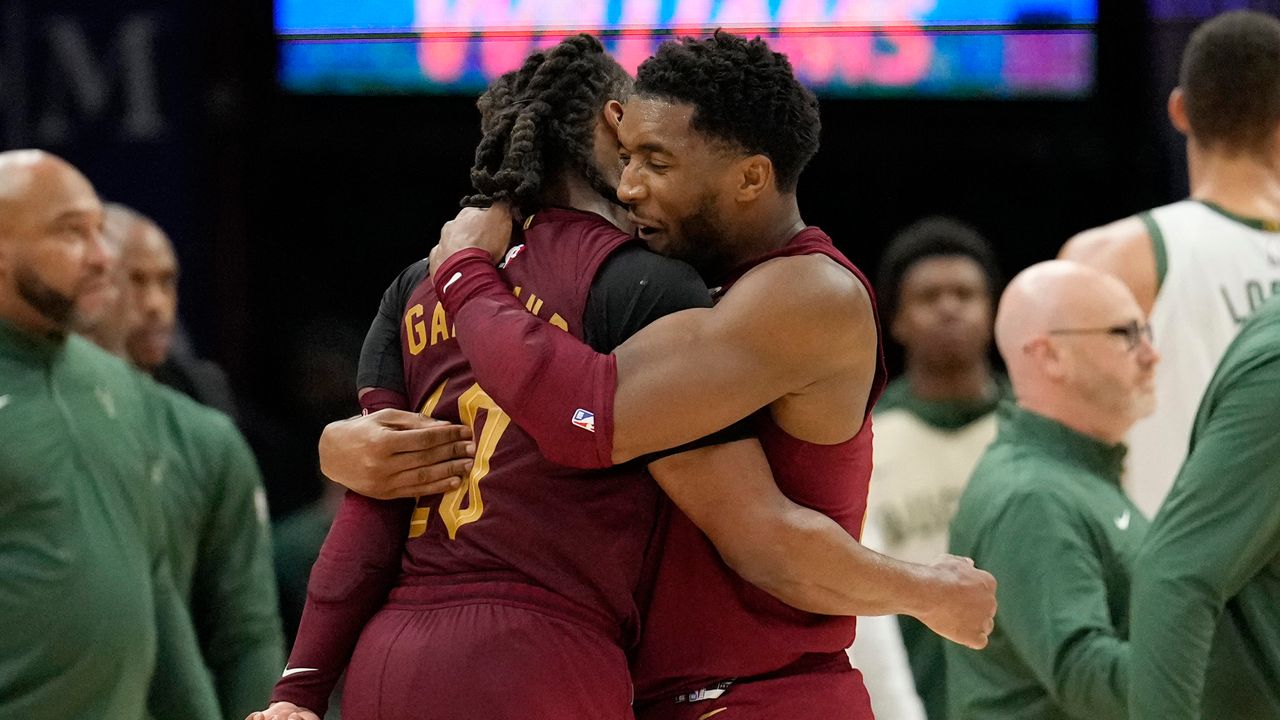 Cleveland Cavaliers guard Donovan Mitchell, right, hugs teammate guard Darius Garland, left, late in the second half of an NBA basketball game against the Milwaukee Bucks, Monday, Nov. 4, 2024, in Cleveland. (AP Photo/Sue Ogrocki)