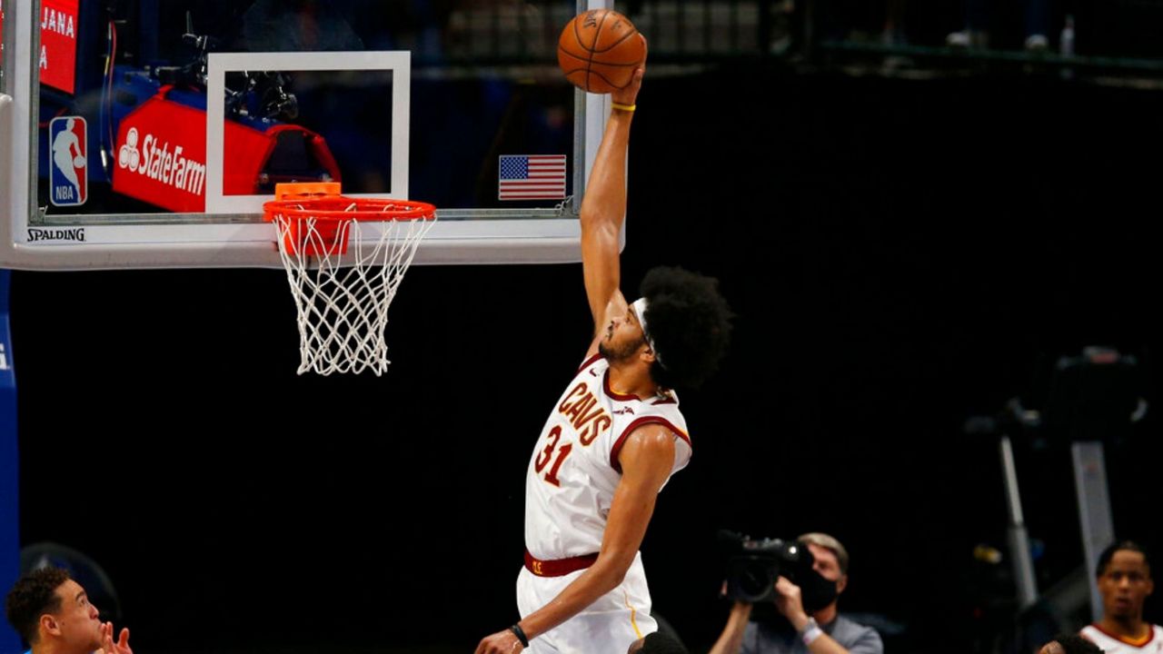 Cleveland Cavaliers center Jarrett Allen (31) comes in for the dunk attempt in front of Dallas Mavericks defenders Willie Cauley-Stein (33) and Tim Hardaway Jr., right, during the first half of an NBA basketball game, Friday, May 7, 2021, in Dallas. (AP Photo/Brandon Wade)