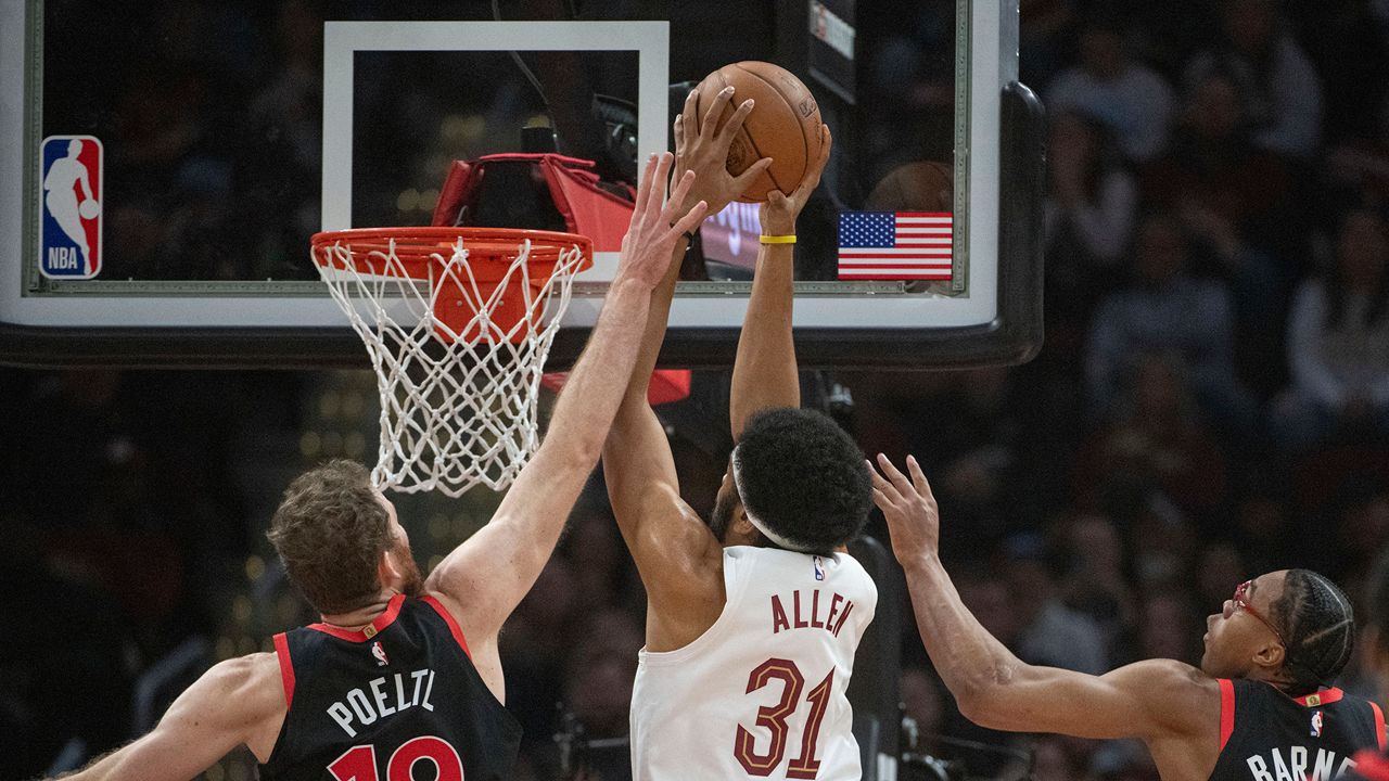 Cleveland Cavaliers' Jarrett Allen (31) dunks as Toronto Raptors' Jakob Poeltl (19) and Scottie Barnes, right, defend during the first half of an NBA basketball game in Cleveland, Sunday, Nov 24, 2024. (AP Photo/Phil Long)