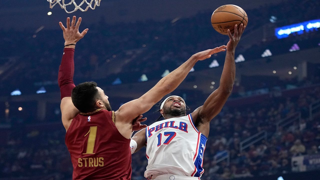 Philadelphia 76ers guard Buddy Hield (17) shoots in front of Cleveland Cavaliers guard Max Strus (1) in the first half of an NBA basketball game, Monday, Feb. 12, 2024, in Cleveland. (AP Photo/Sue Ogrocki)