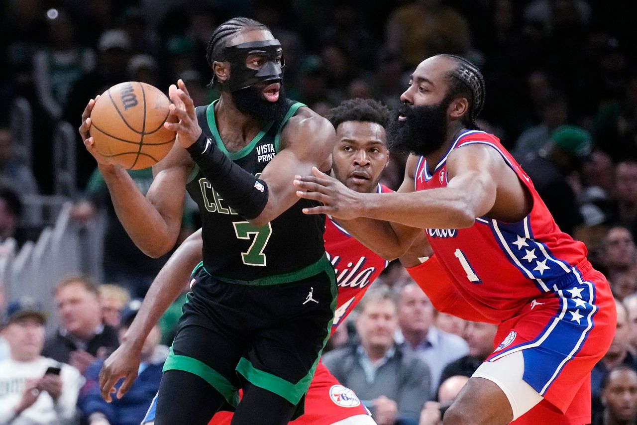 Boston Celtics guard Jaylen Brown (7) looks to pass while pressured by Philadelphia 76ers guard James Harden (1) during the first half of Game 1 in the NBA basketball Eastern Conference semifinals playoff series, Monday, May 1, in Boston. (AP Photo/Charles Krupa)