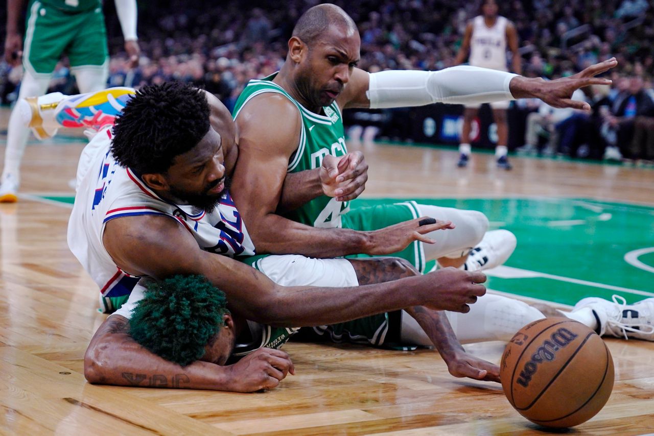 Philadelphia 76ers center Joel Embiid battles for a loose ball with Boston Celtics center Al Horford, right, and guard Marcus Smart, bottom, during the second half of Game 2 in the NBA basketball Eastern Conference semifinals playoff series, Wednesday, May 3, in Boston. (AP Photo/Charles Krupa)