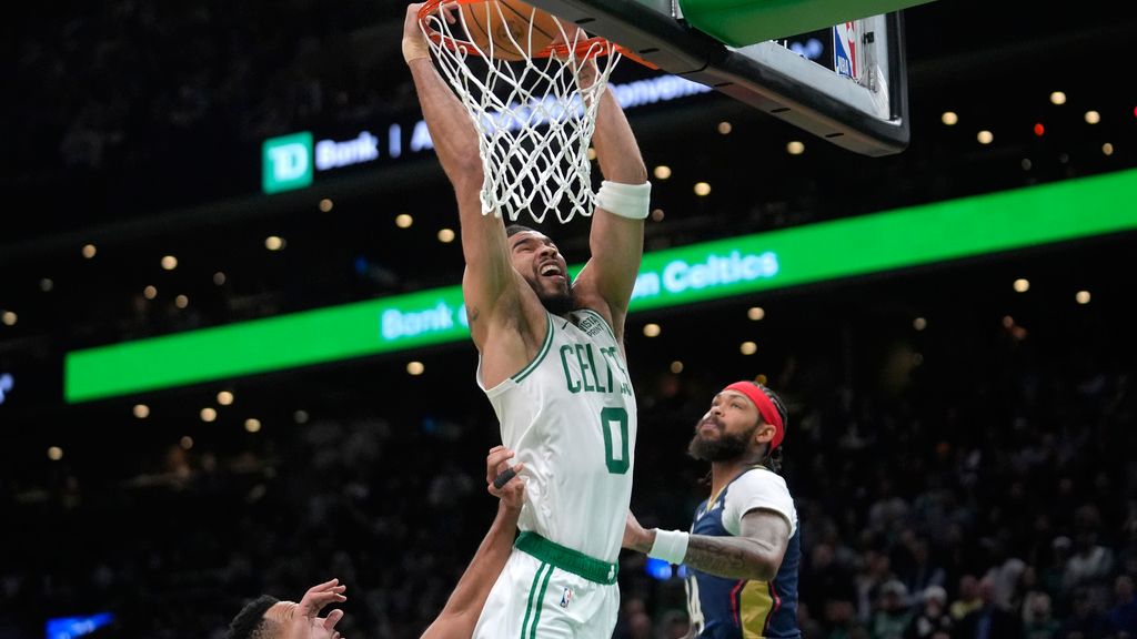 Boston Celtics forward Jayson Tatum (0) dunks the ball to score in front of New Orleans Pelicans forward Brandon Ingram, right, in the second half of an NBA basketball game, Monday, Jan. 29, 2024, in Boston. (AP Photo/Steven Senne)