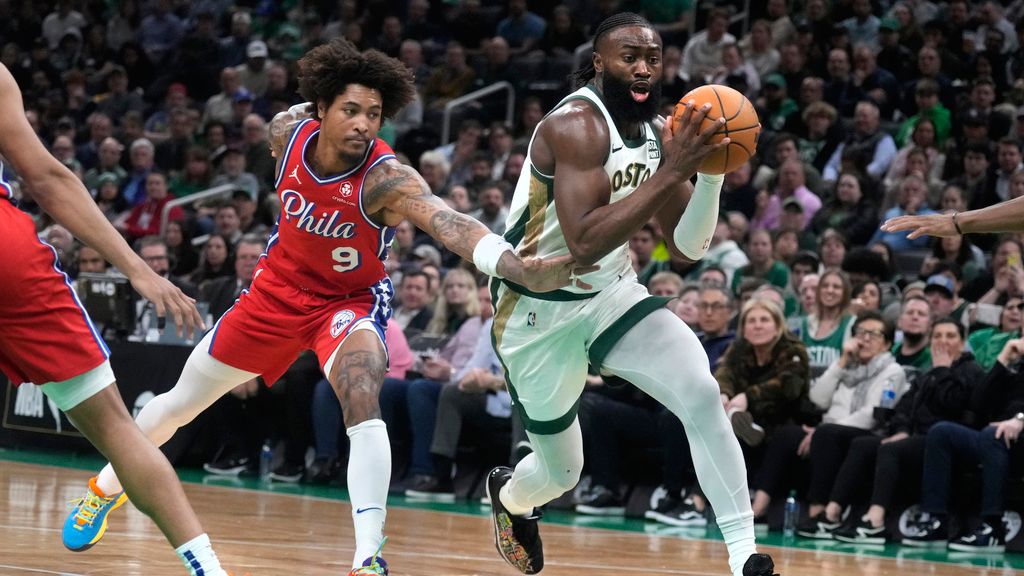 Boston Celtics guard Jaylen Brown, right, drives to the basket past Philadelphia 76ers guard Kelly Oubre Jr. (9) during the first half of an NBA basketball game, Tuesday, Feb. 27, 2024, in Boston. (AP Photo/Charles Krupa)