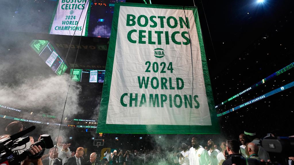 The Boston Celtics 2024 World Championship banner is raised prior to an NBA basketball game against the New York Knicks, Tuesday, Oct. 22, 2024, in Boston. (AP Photo/Charles Krupa)